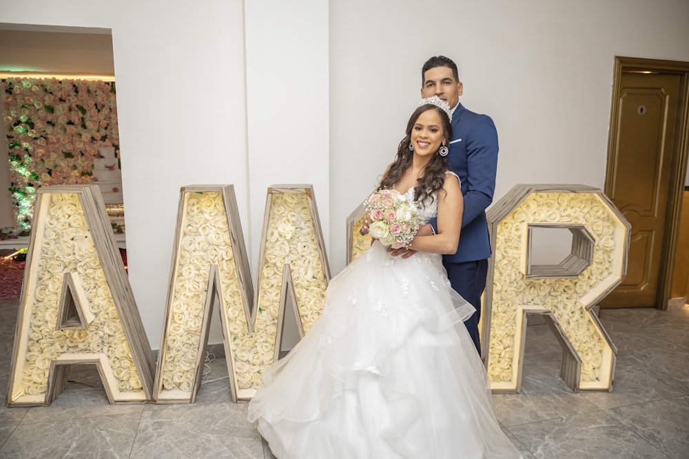 a bride and groom posing in front of a marquee