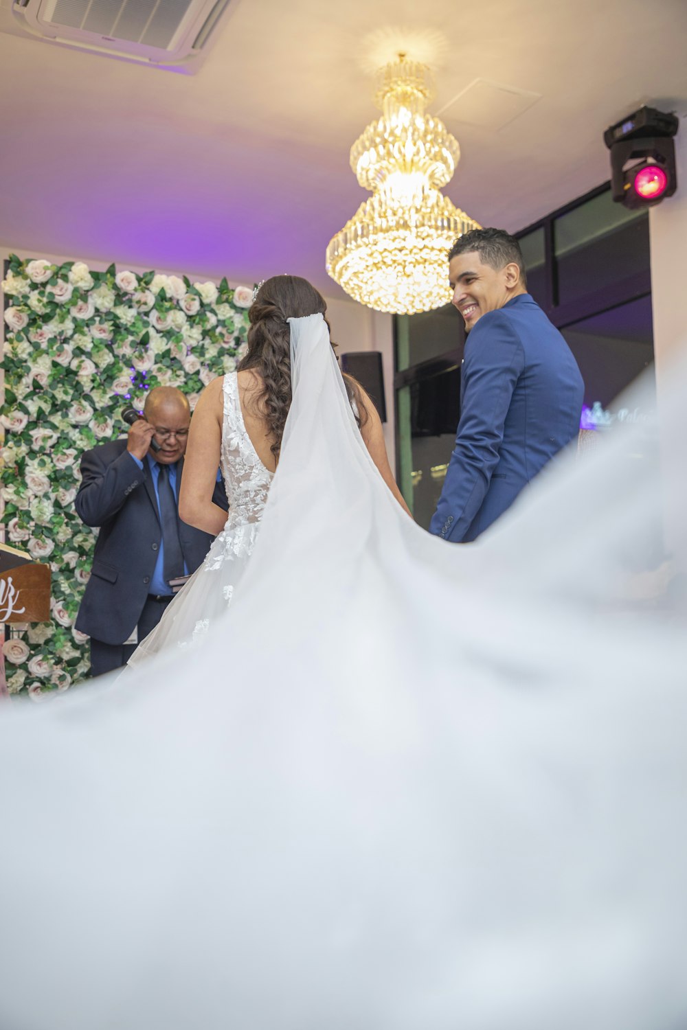 a bride and groom standing in front of a wedding cake