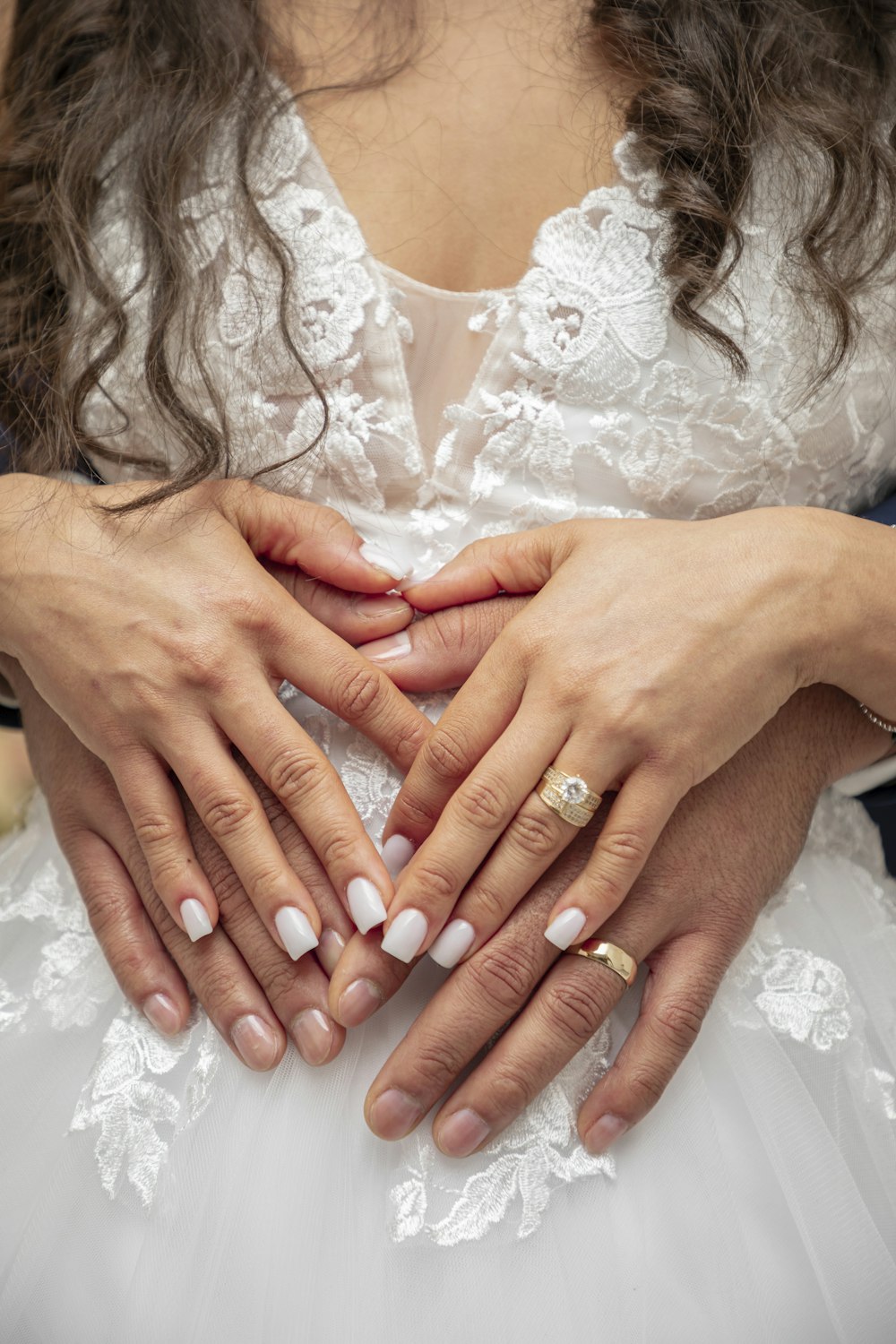 une femme en robe de mariée tenant ses mains jointes