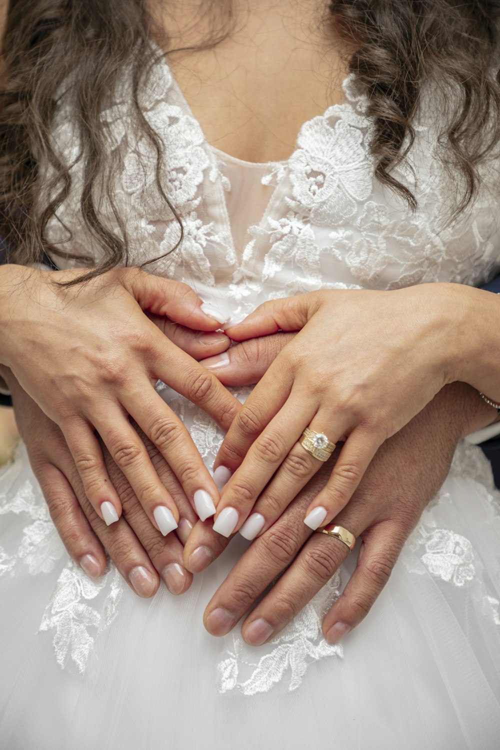 a woman in a wedding dress holding her hands together