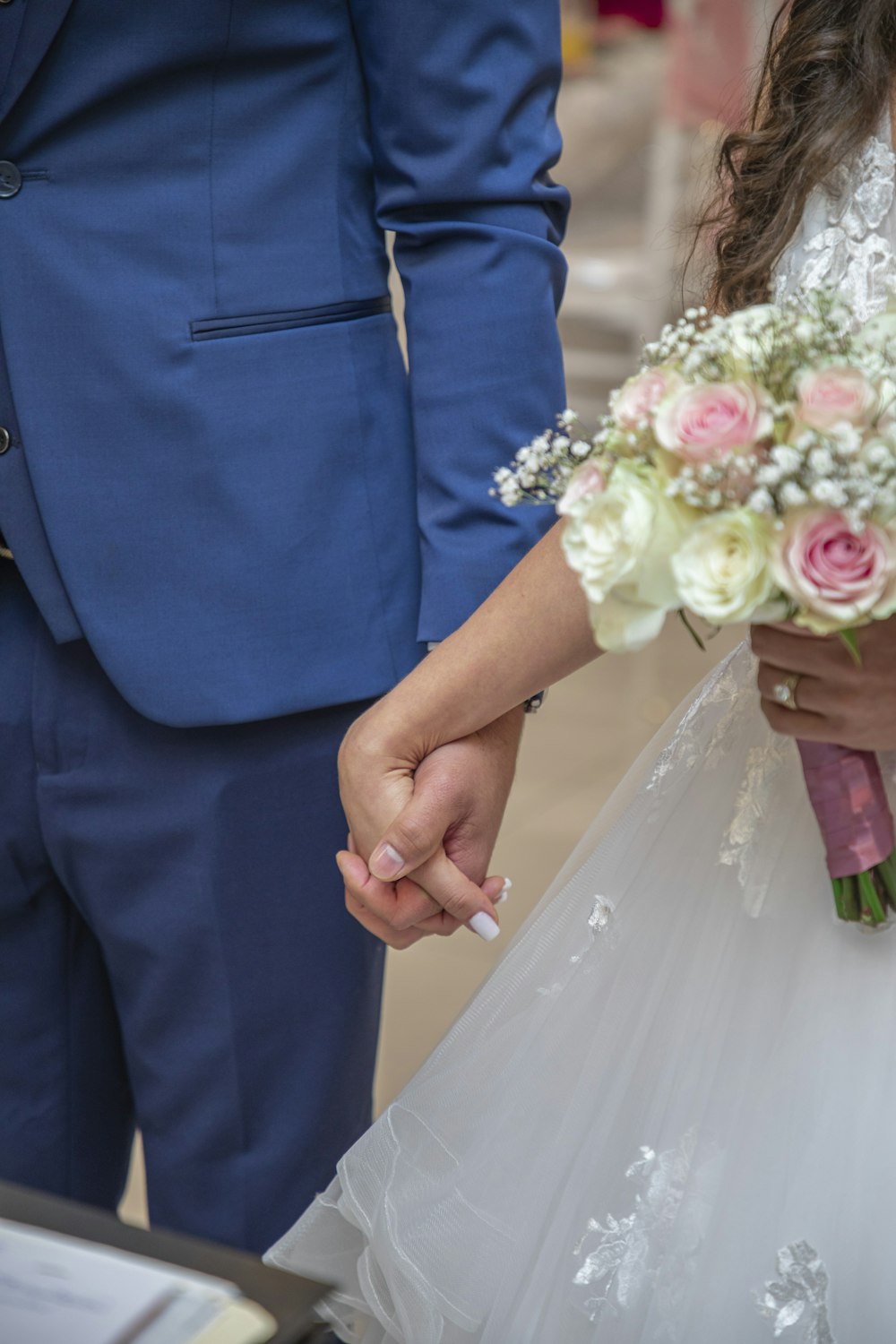 a bride and groom hold hands as they walk down the aisle