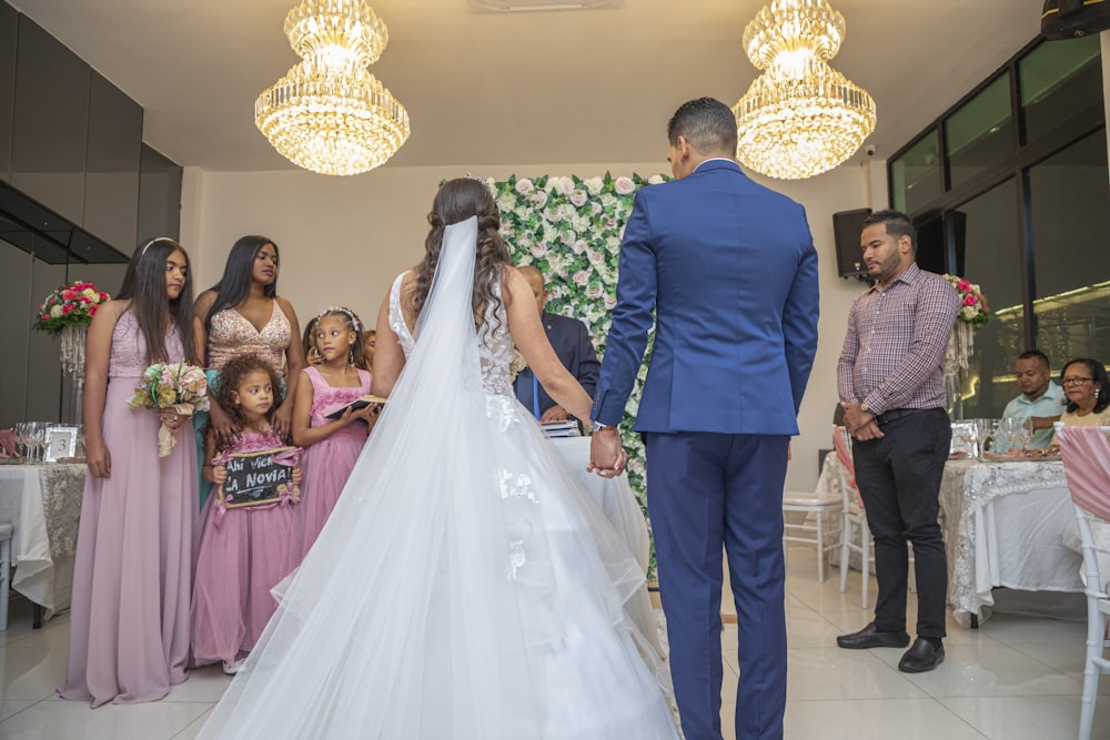 a bride and groom standing in front of a group of people