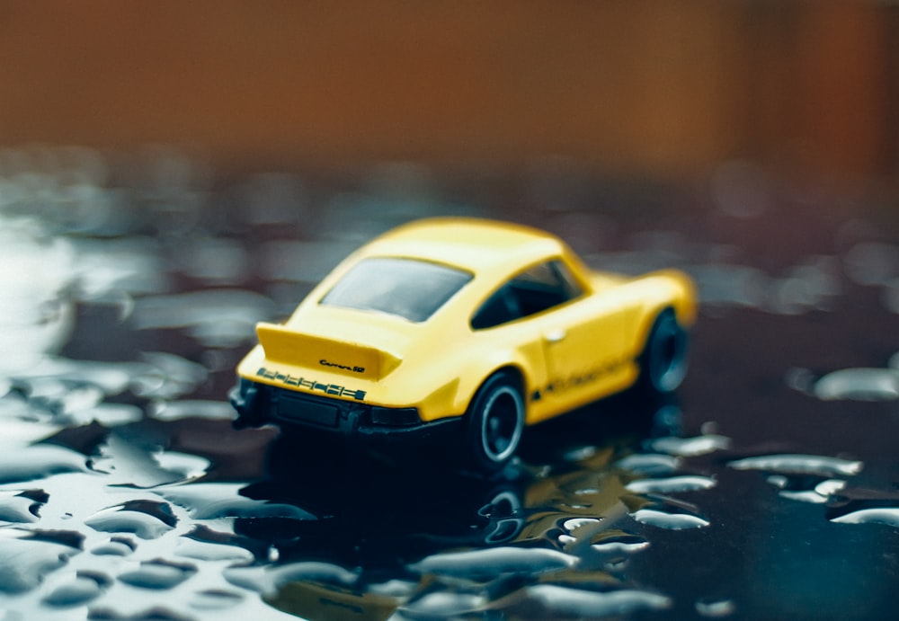 a yellow toy car sitting on top of a table