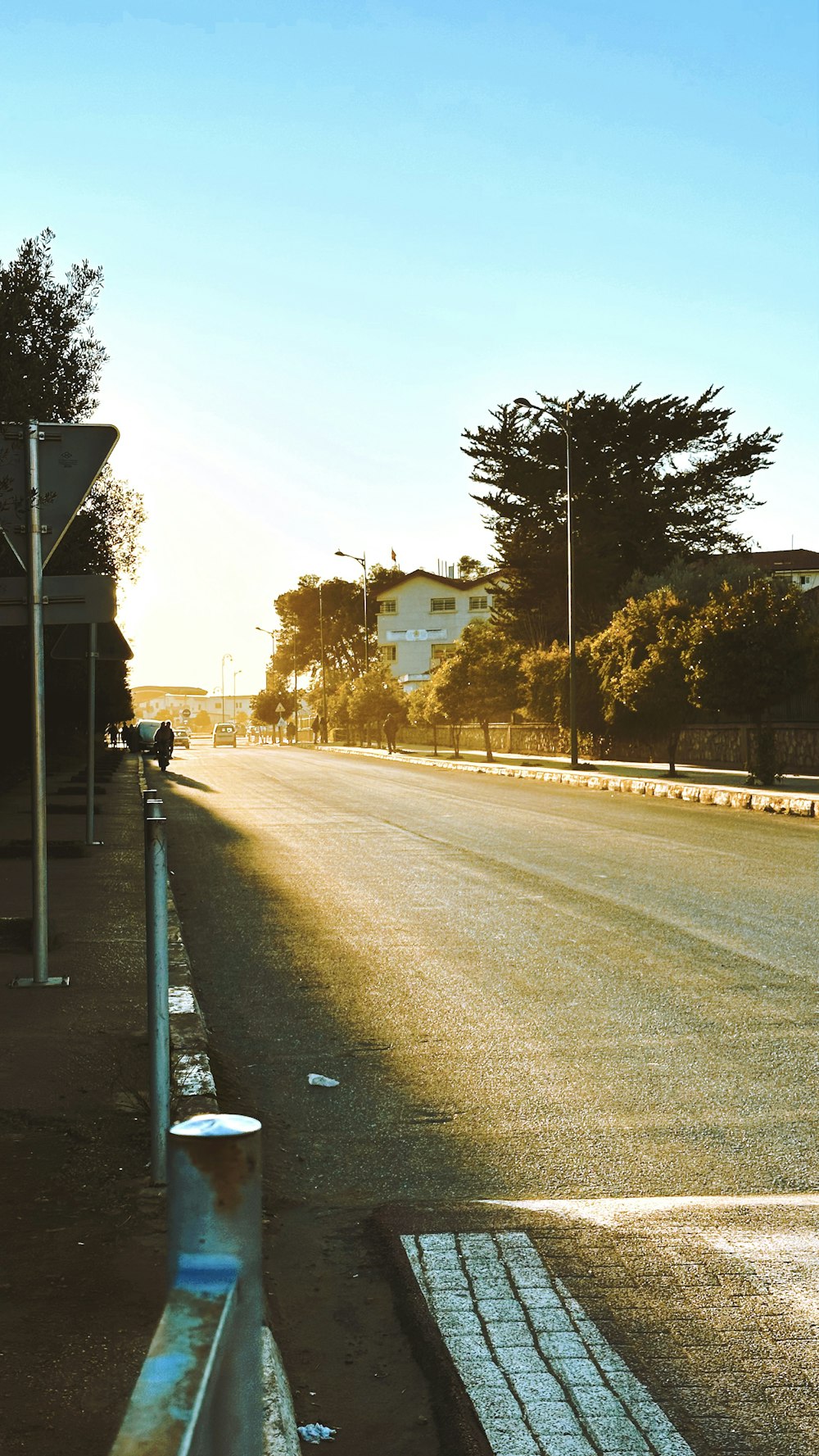 a street with a fence and a street sign on the side of the road