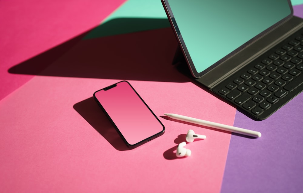 a laptop computer sitting on top of a pink and green table