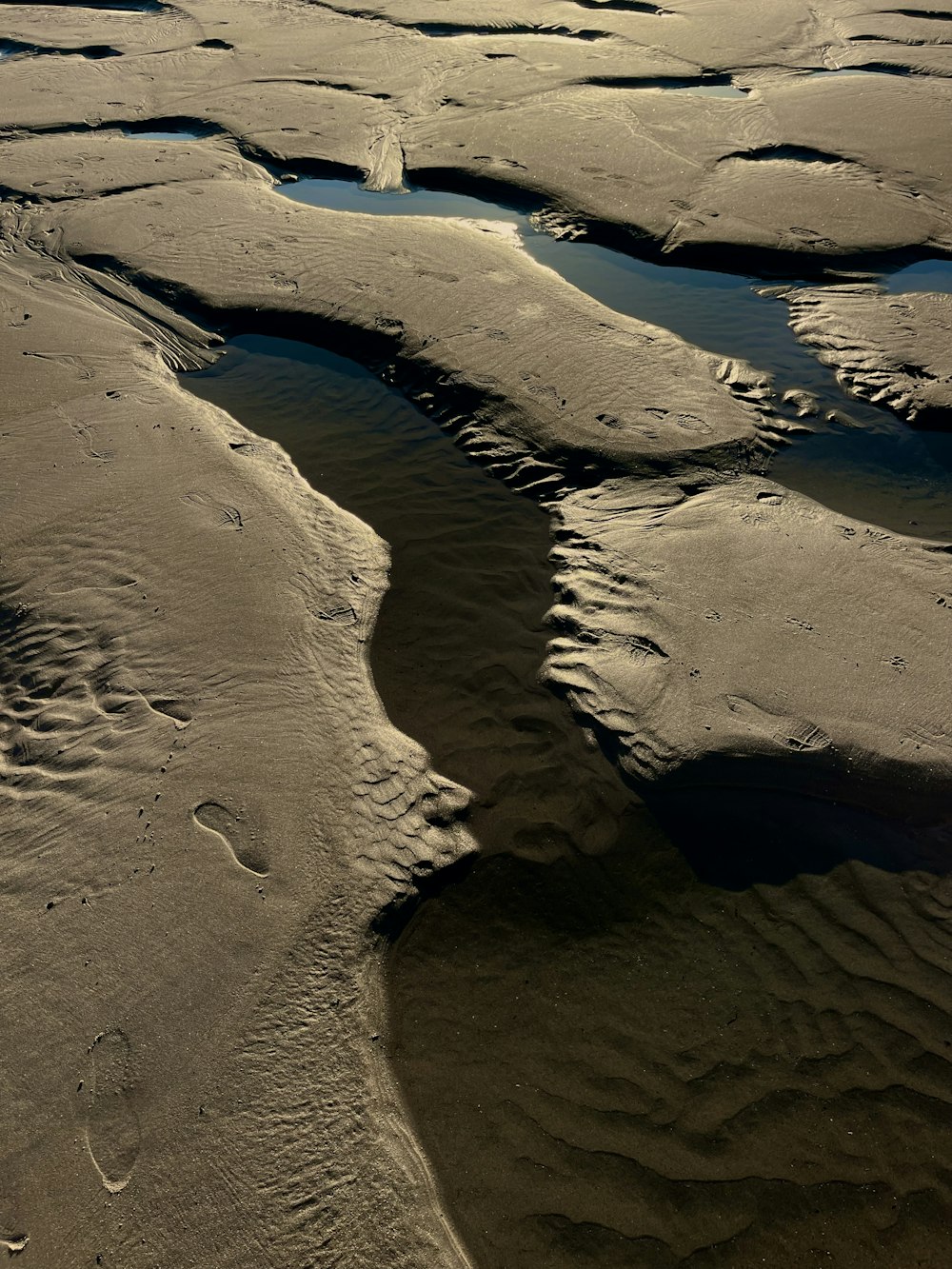 une vue aérienne d’une rivière traversant une plage de sable