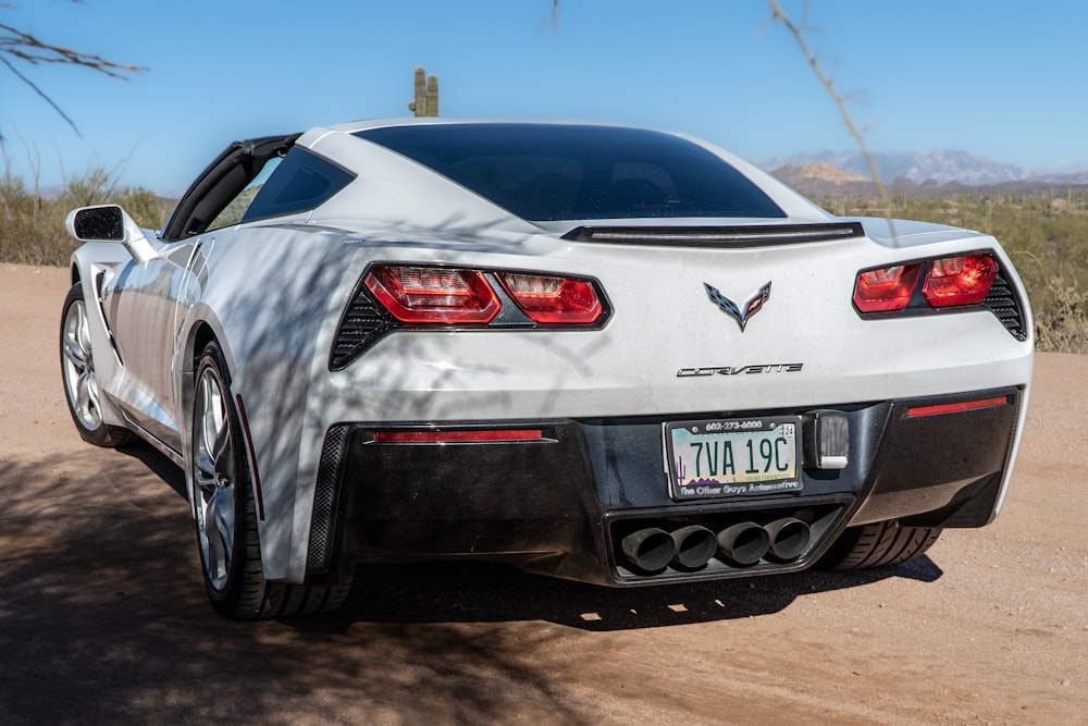 a white car parked on a dirt road