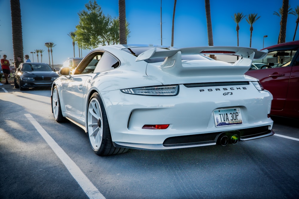 a white sports car parked in a parking lot