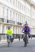 a couple of people riding bikes down a street