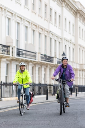 a couple of people riding bikes down a street