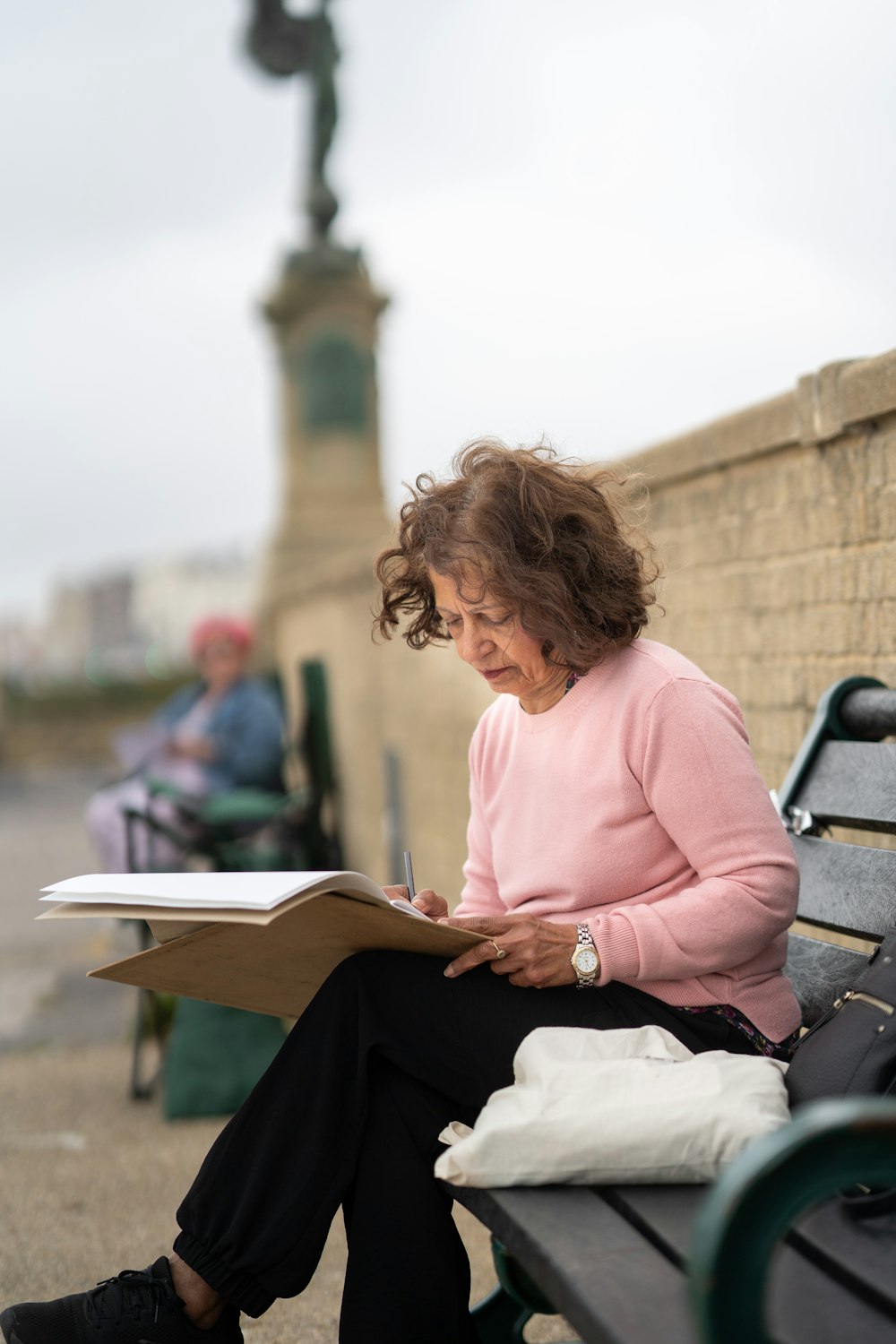 a woman sitting on a bench reading a book