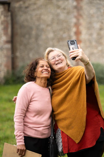 deux femmes prennent une photo avec un téléphone portable