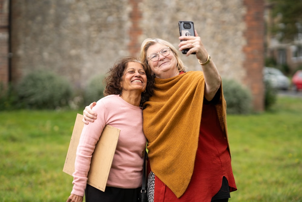 two women taking a picture with a cell phone