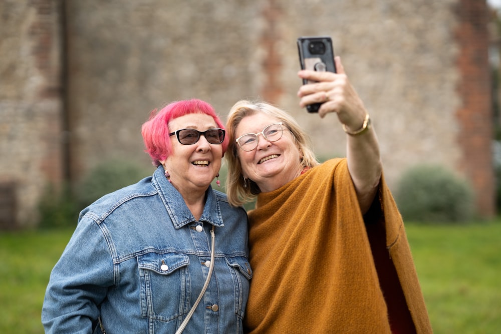 two women taking a picture with a cell phone