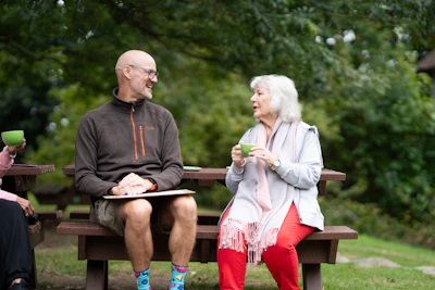 a man and a woman sitting on a park bench