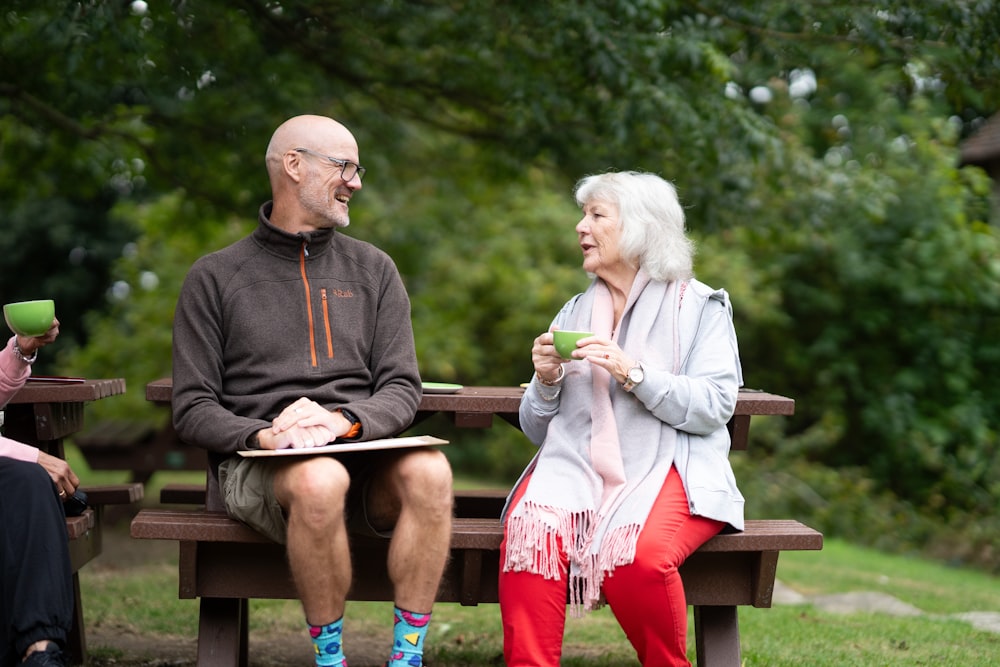 a man and a woman sitting on a park bench