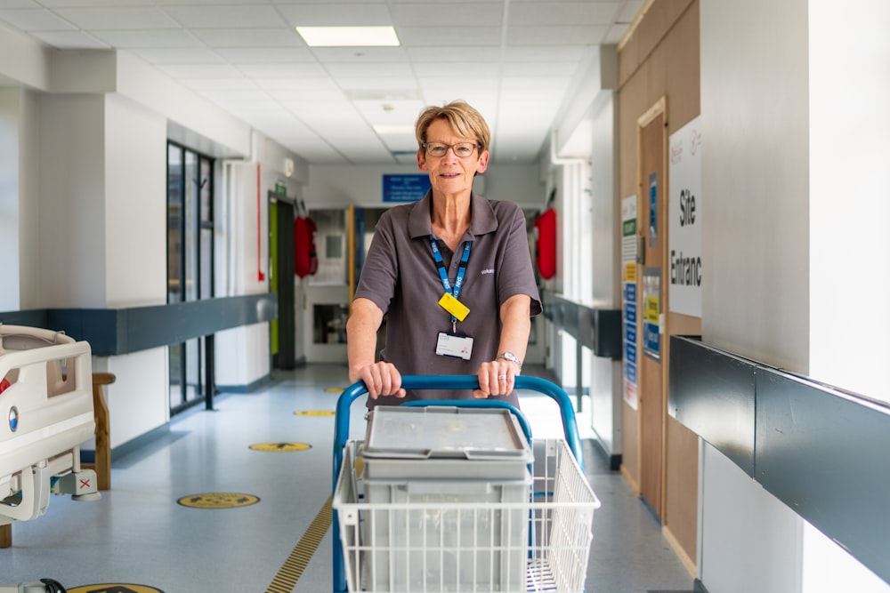 a woman pushing a shopping cart down a hallway