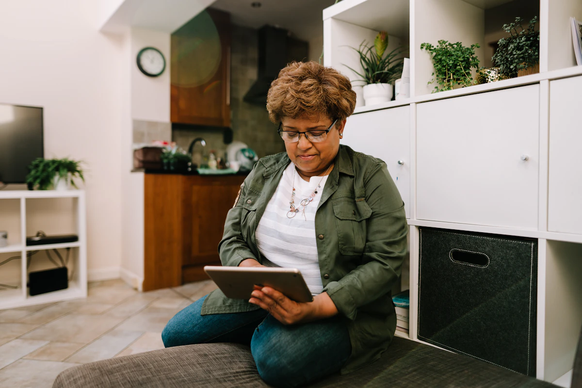 Happy senior smiling while using a tablet to join a Valia Live session