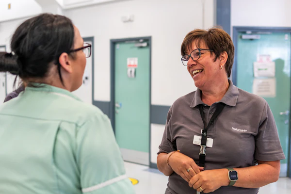 Two healthcare workers talking in a hallway