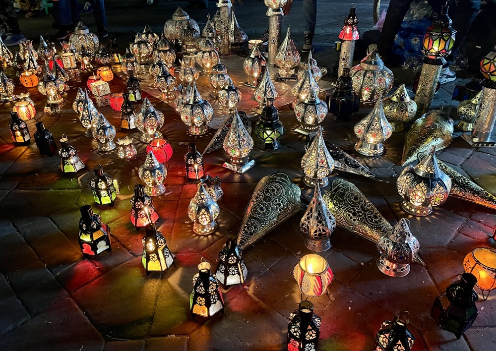 a group of lit up candles sitting on top of a stone floor