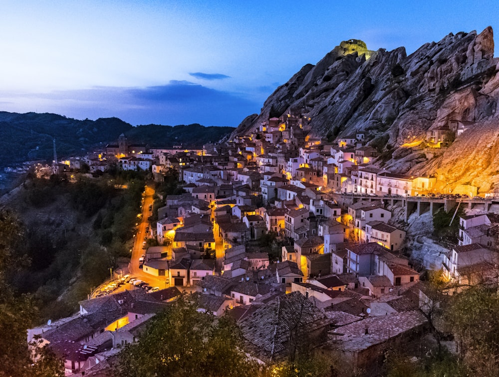 a village is lit up at night in the mountains