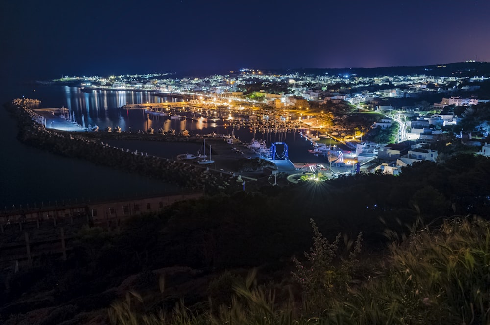 uma vista de uma cidade à noite de uma colina