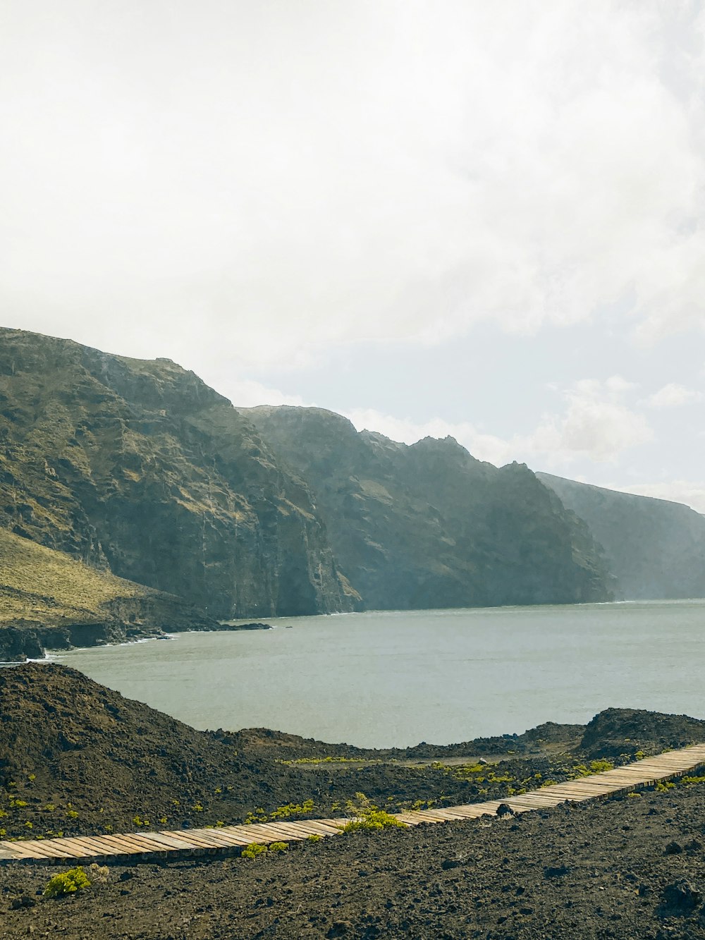 a scenic view of a body of water with mountains in the background