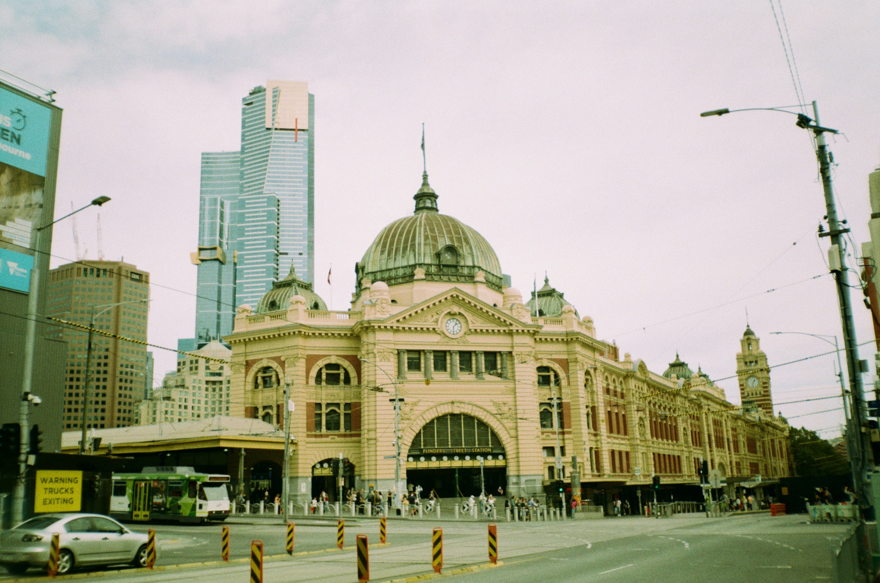 a train station in a city with tall buildings, 