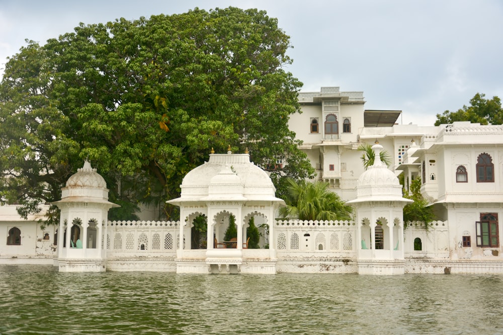 a large white building sitting next to a body of water