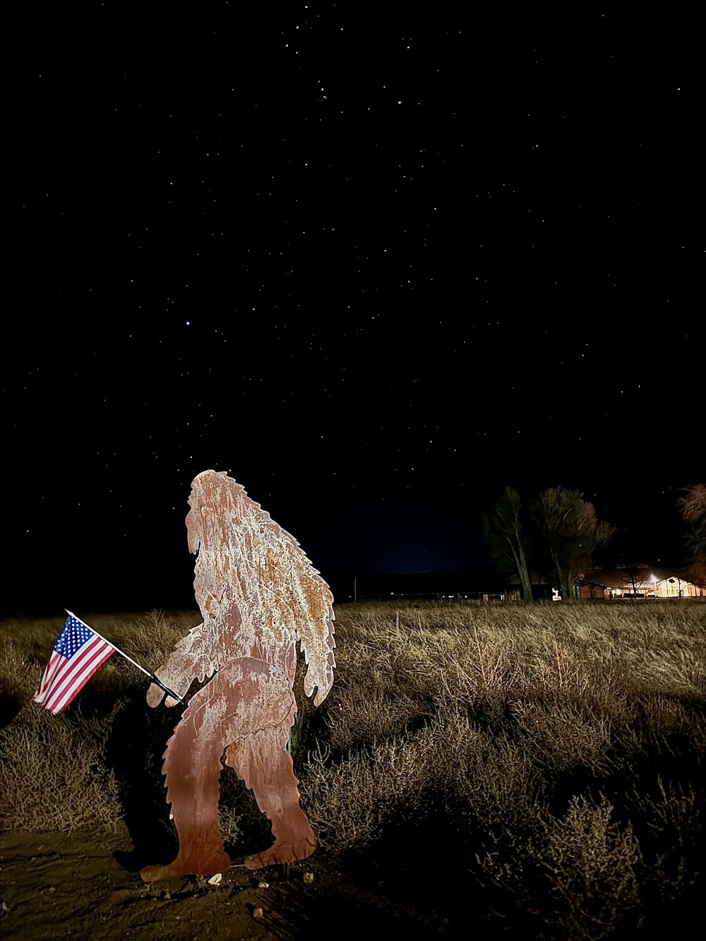 a bigfoot standing in a field holding an american flag