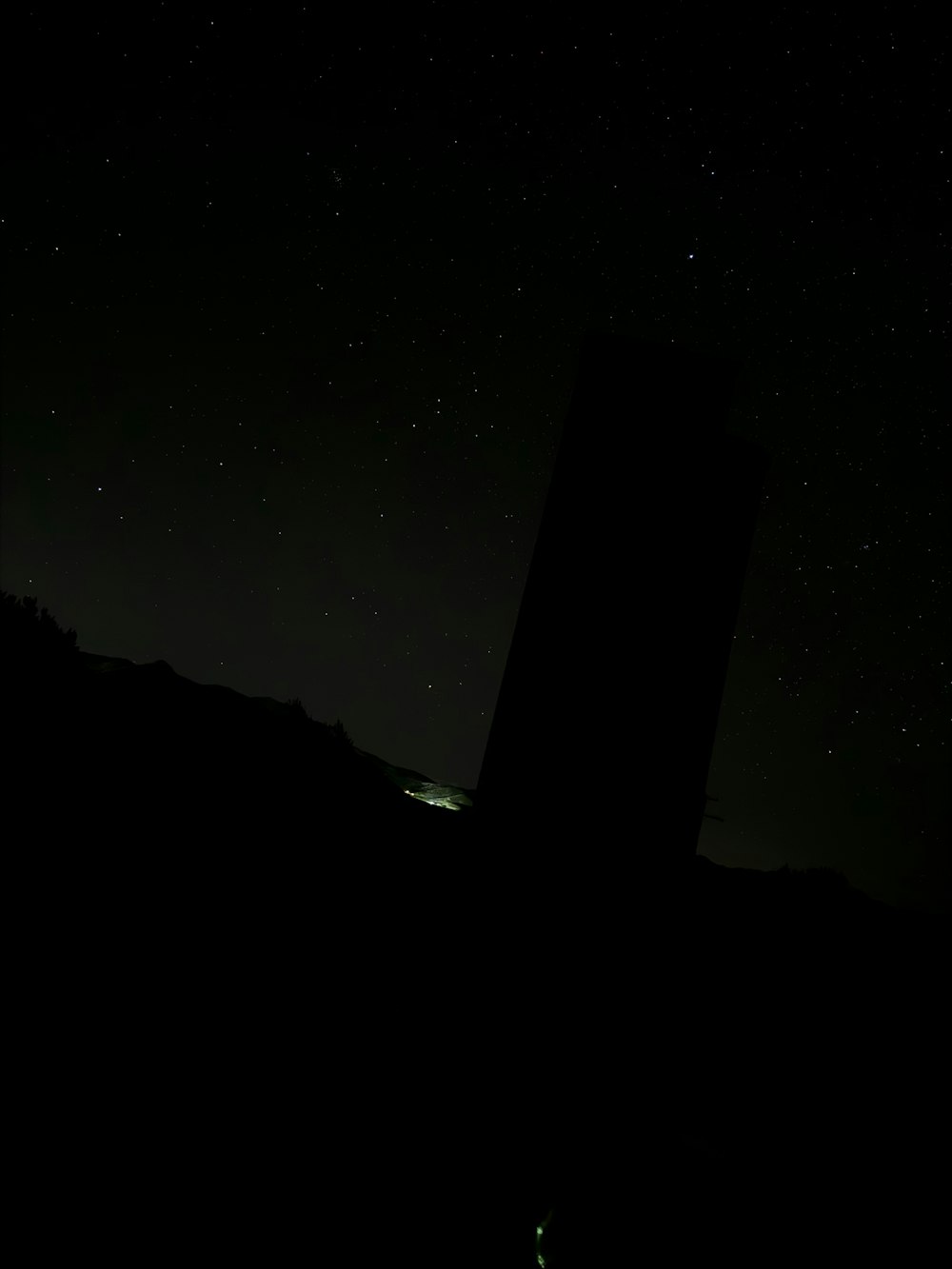 a black tower with a clock on it at night