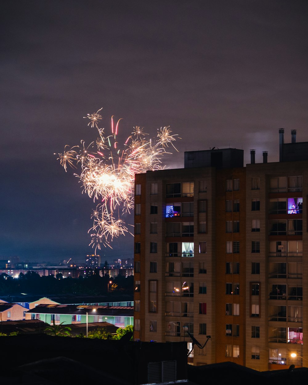 fireworks are lit up in the night sky over a city