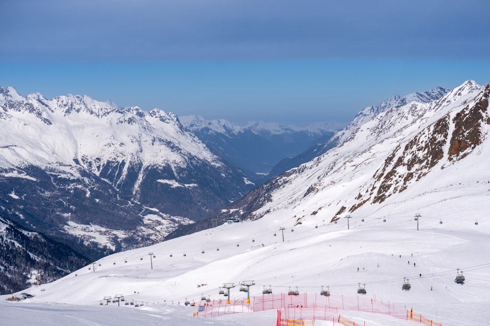 a snowy mountain with a ski lift in the distance