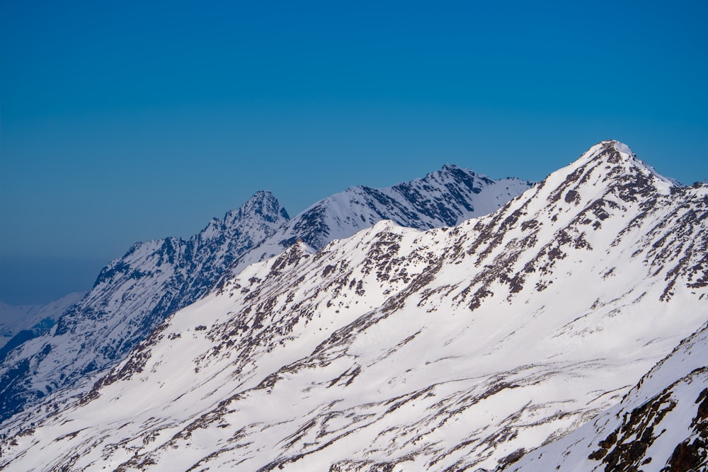 a snow covered mountain with a blue sky in the background