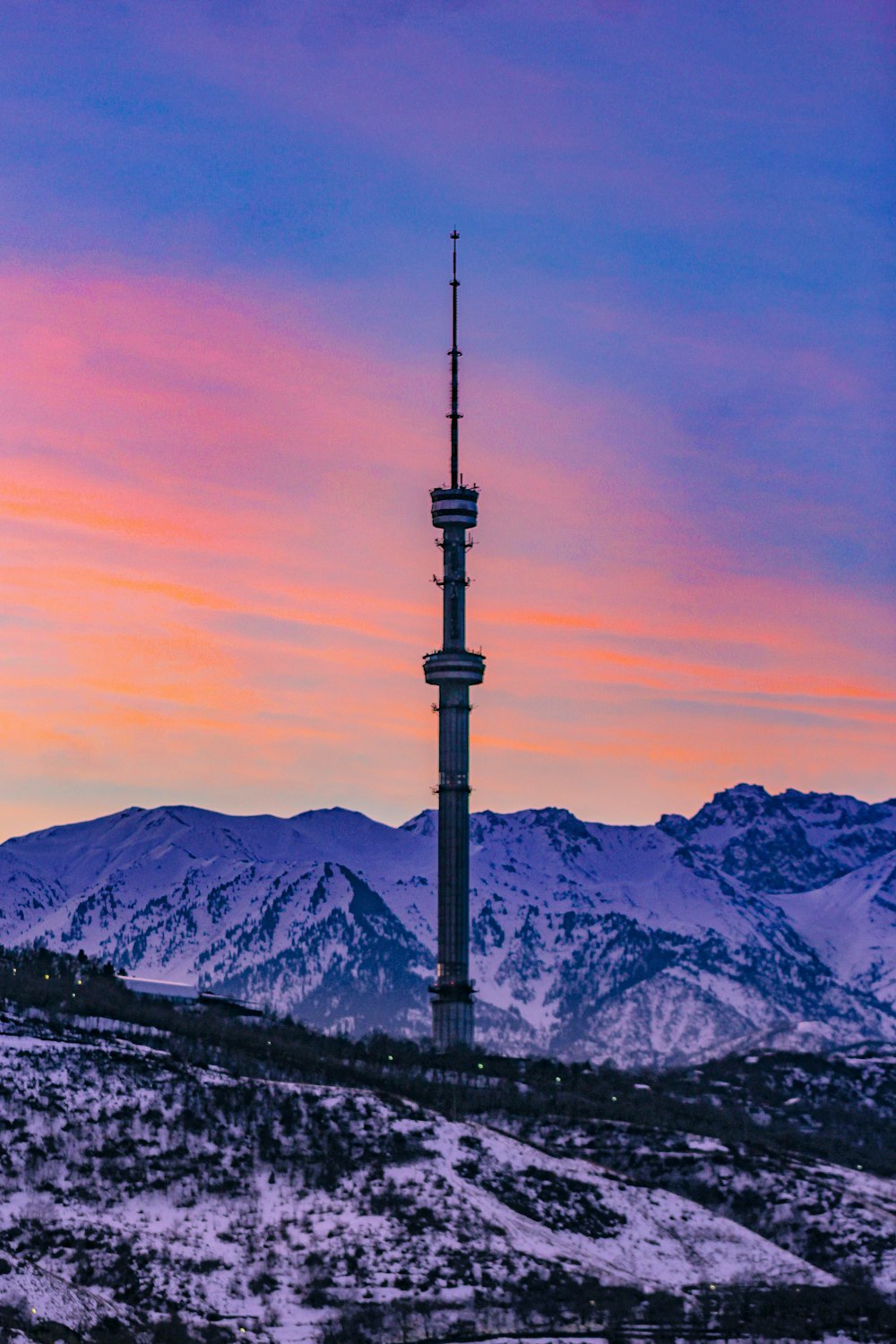 a very tall tower sitting on top of a snow covered hill
