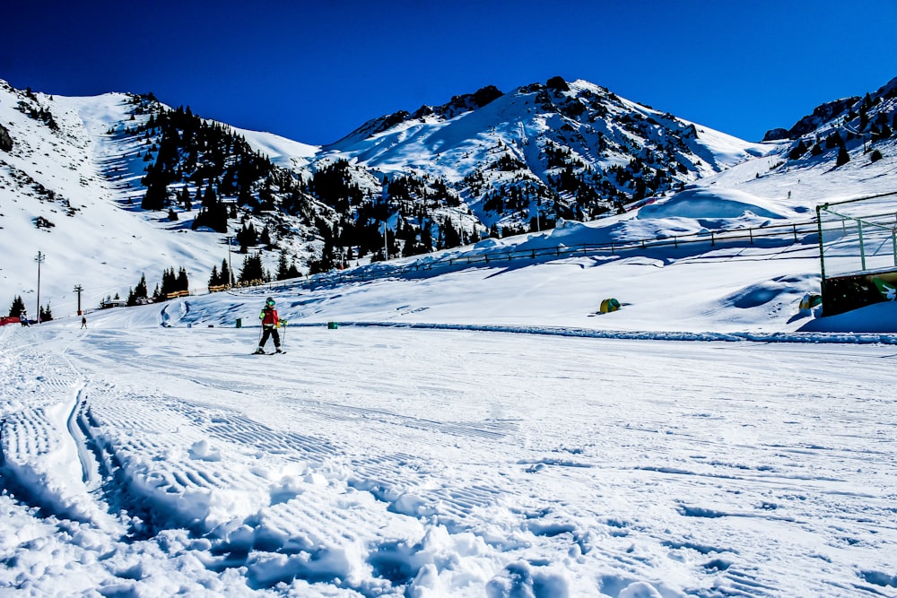 a man riding skis down a snow covered slope