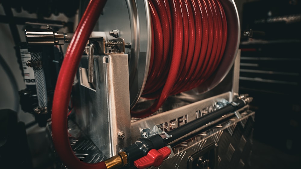 a close up of a red hose connected to a machine