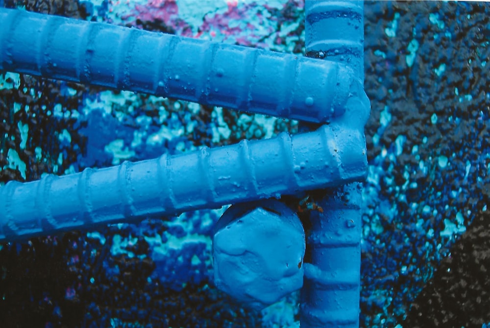 a close up of a blue pipe on a wall
