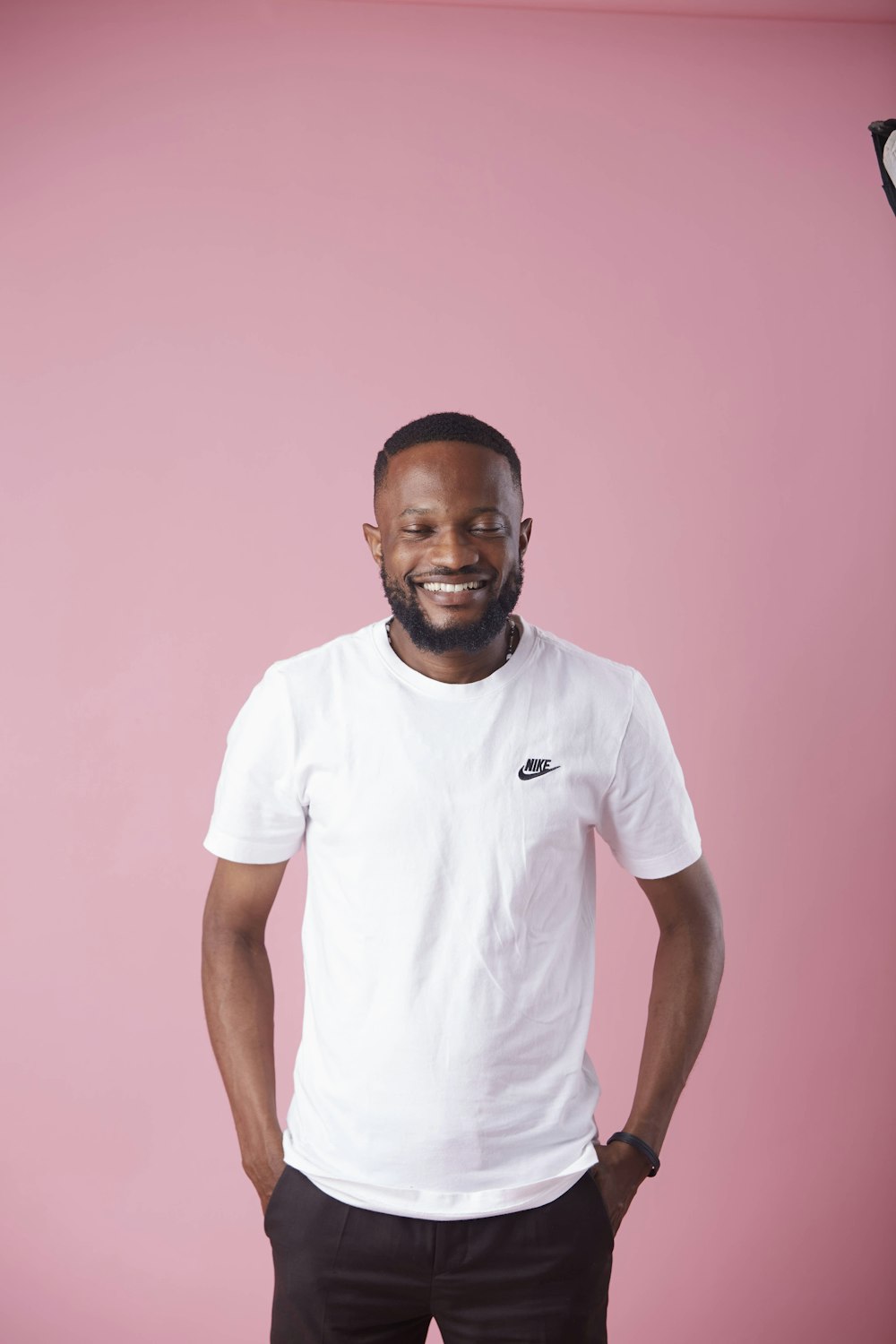 a man standing in front of a pink wall