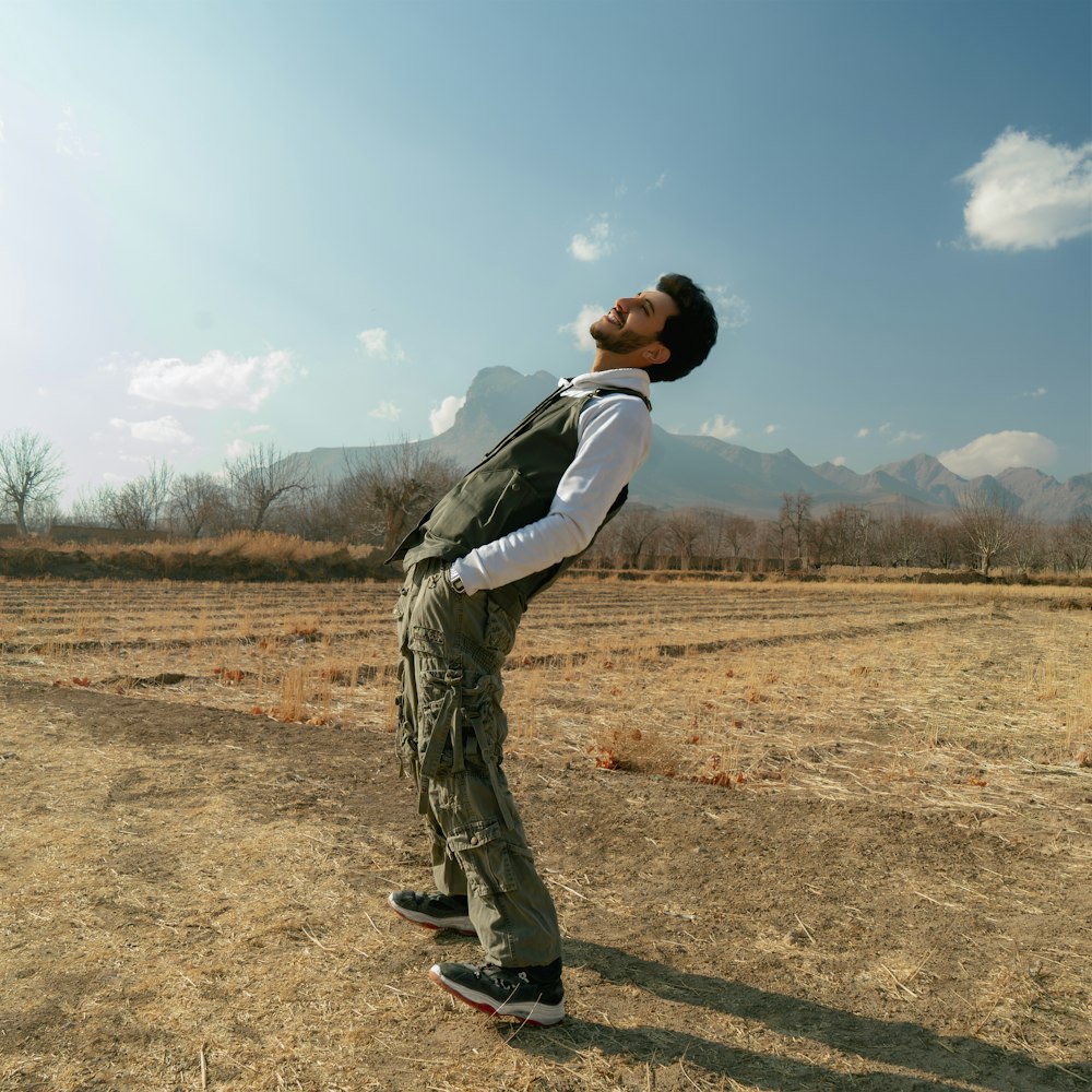 a man standing on a skateboard in the middle of a field