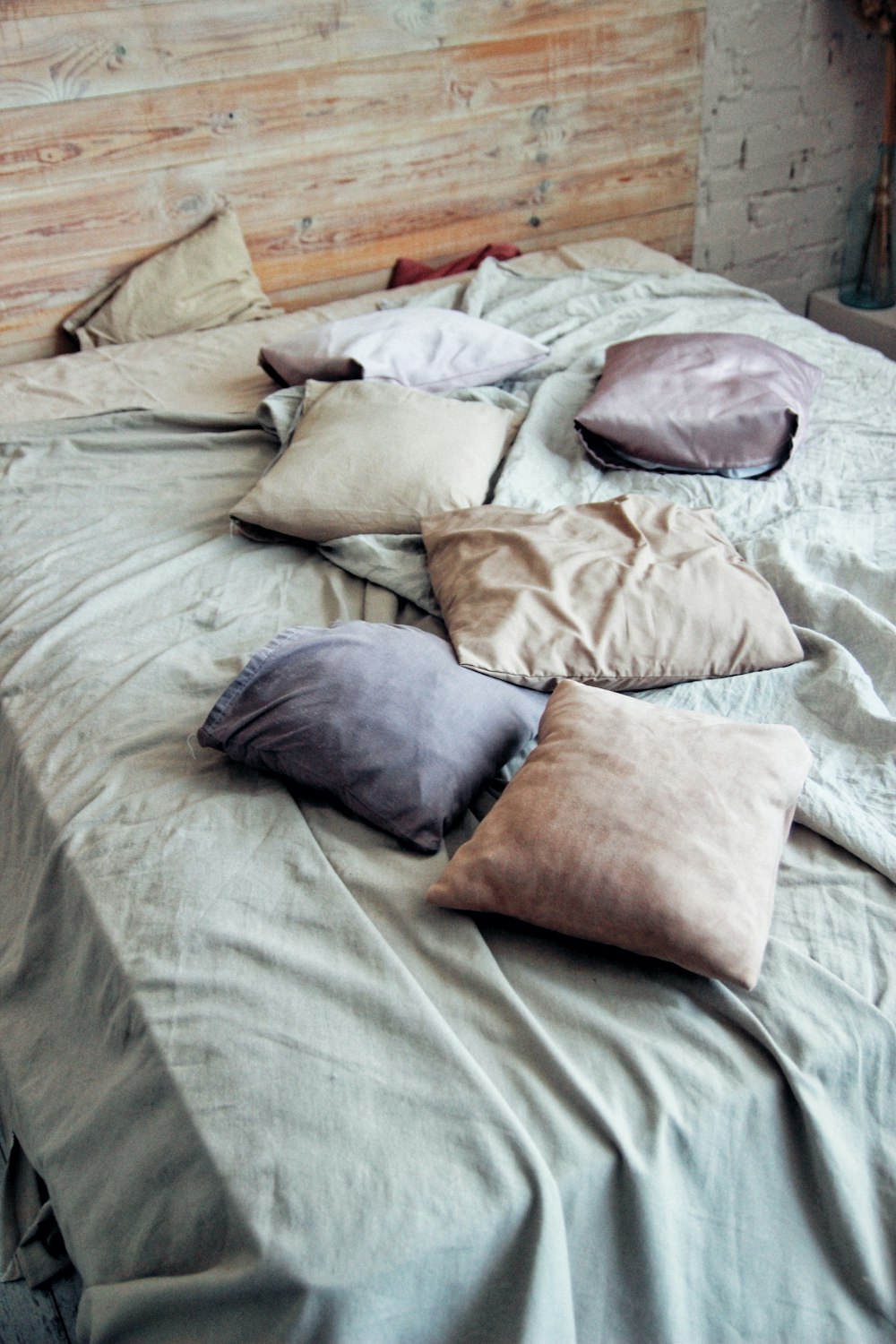 a bed topped with lots of pillows on top of it