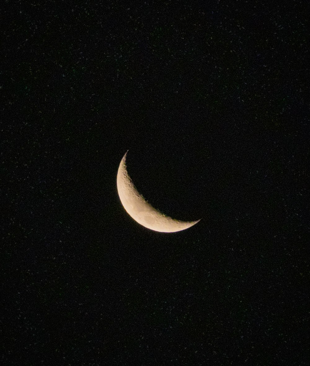 a crescent moon is seen in the night sky