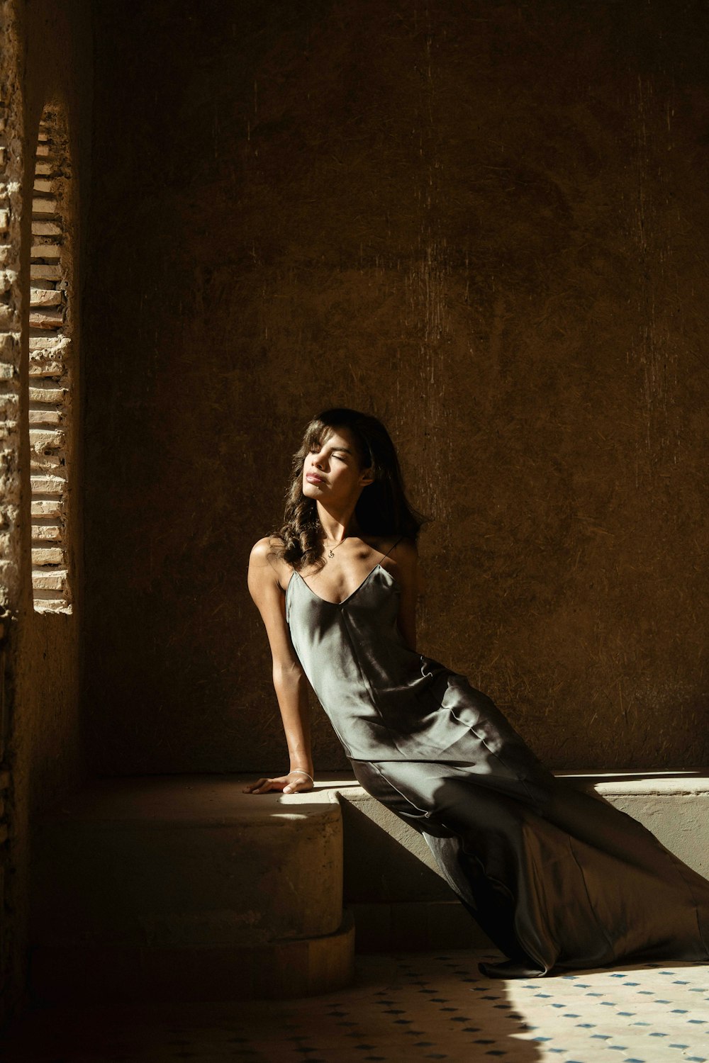 a woman sitting on a ledge in a room