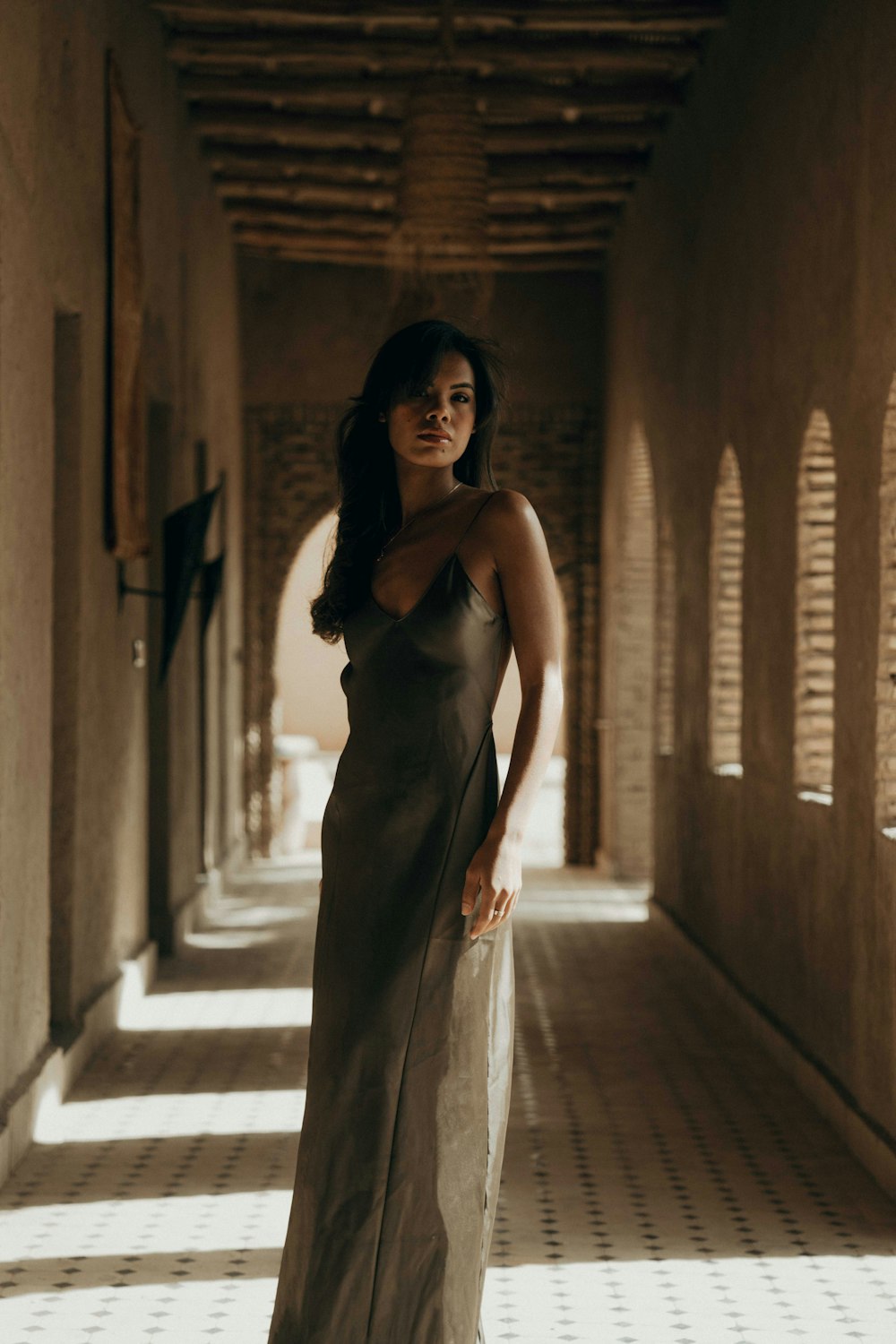 a woman in a long dress standing in a hallway