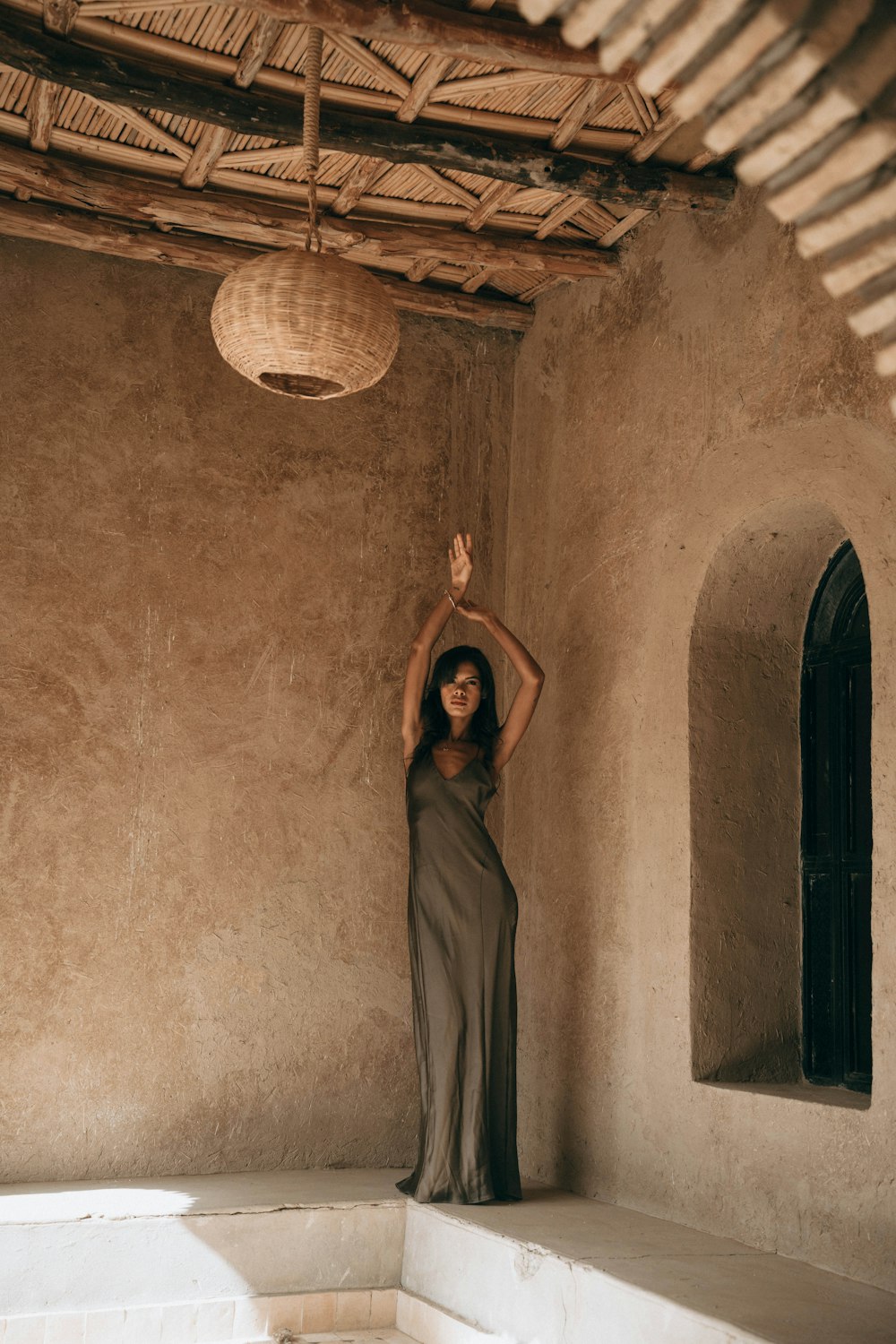 a woman in a long dress standing in a room