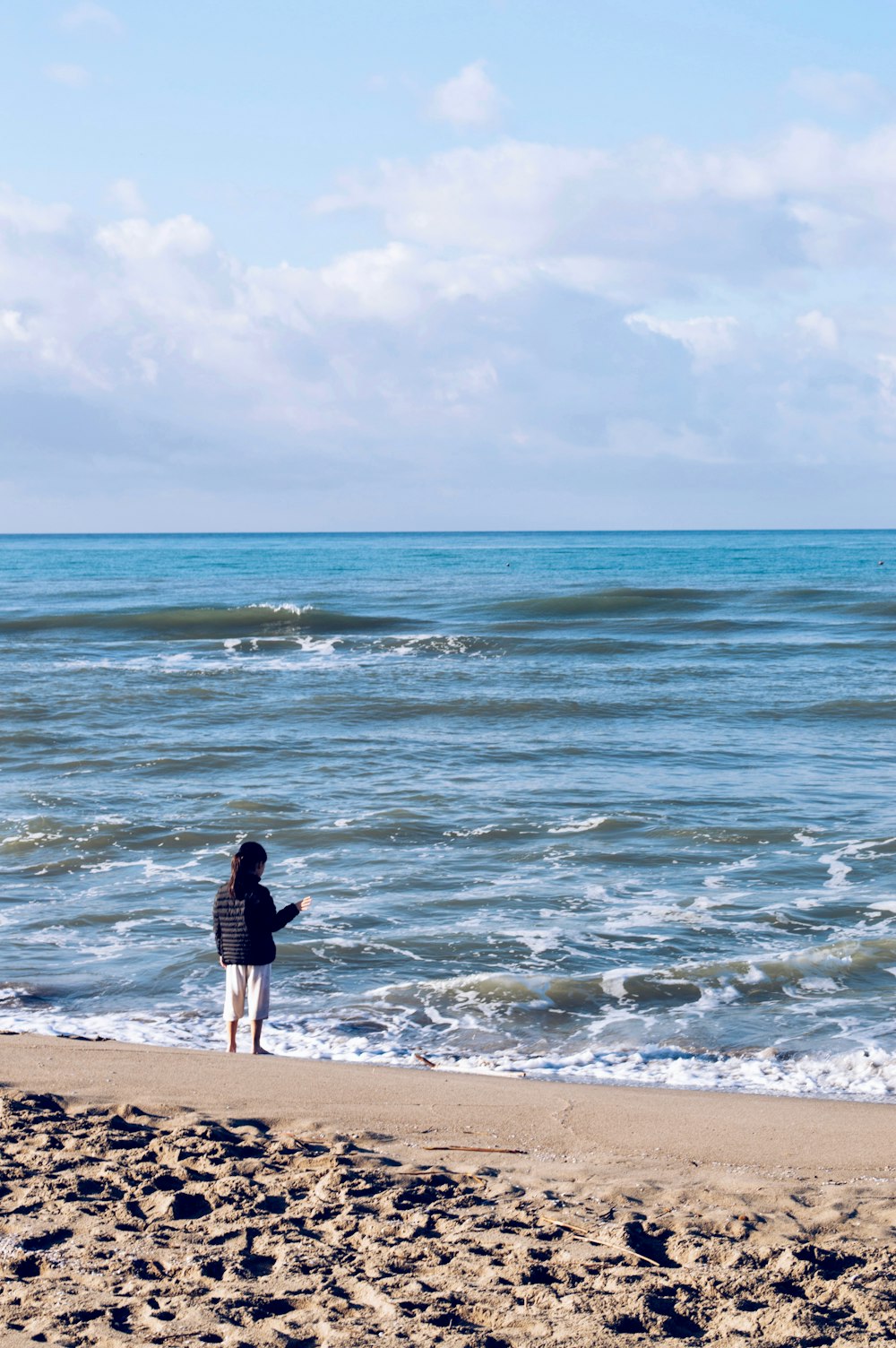 a person standing on a beach near the ocean