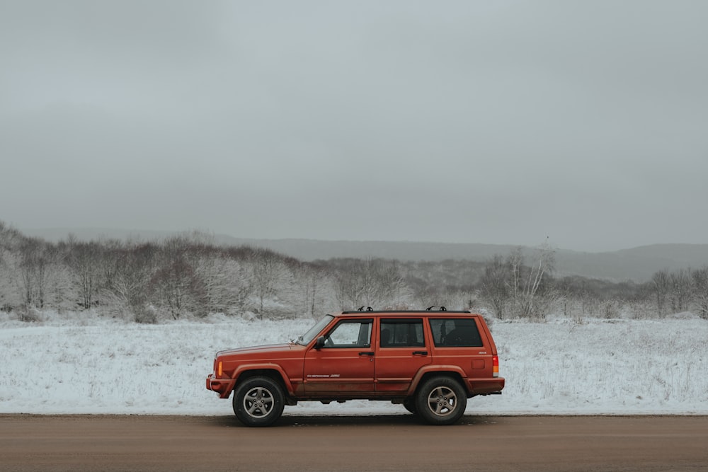 a red jeep parked on the side of a road