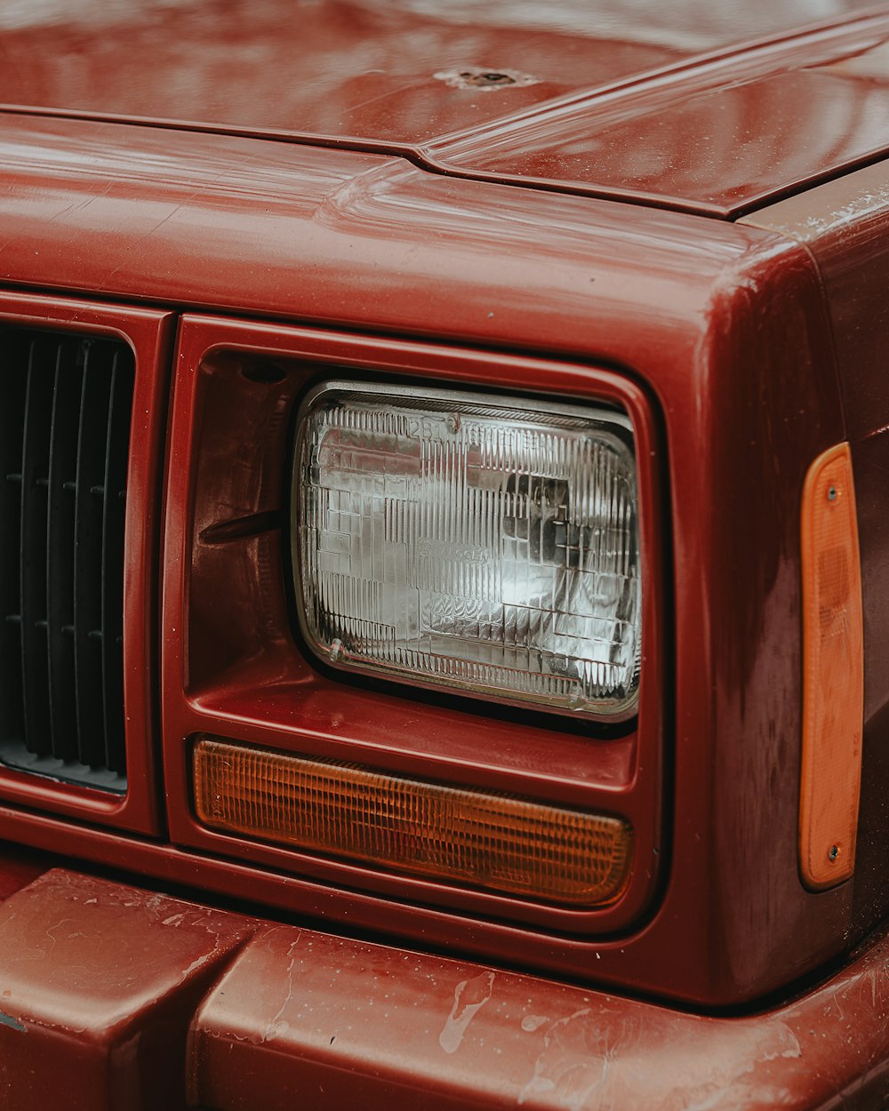 a close up of the front end of a red truck