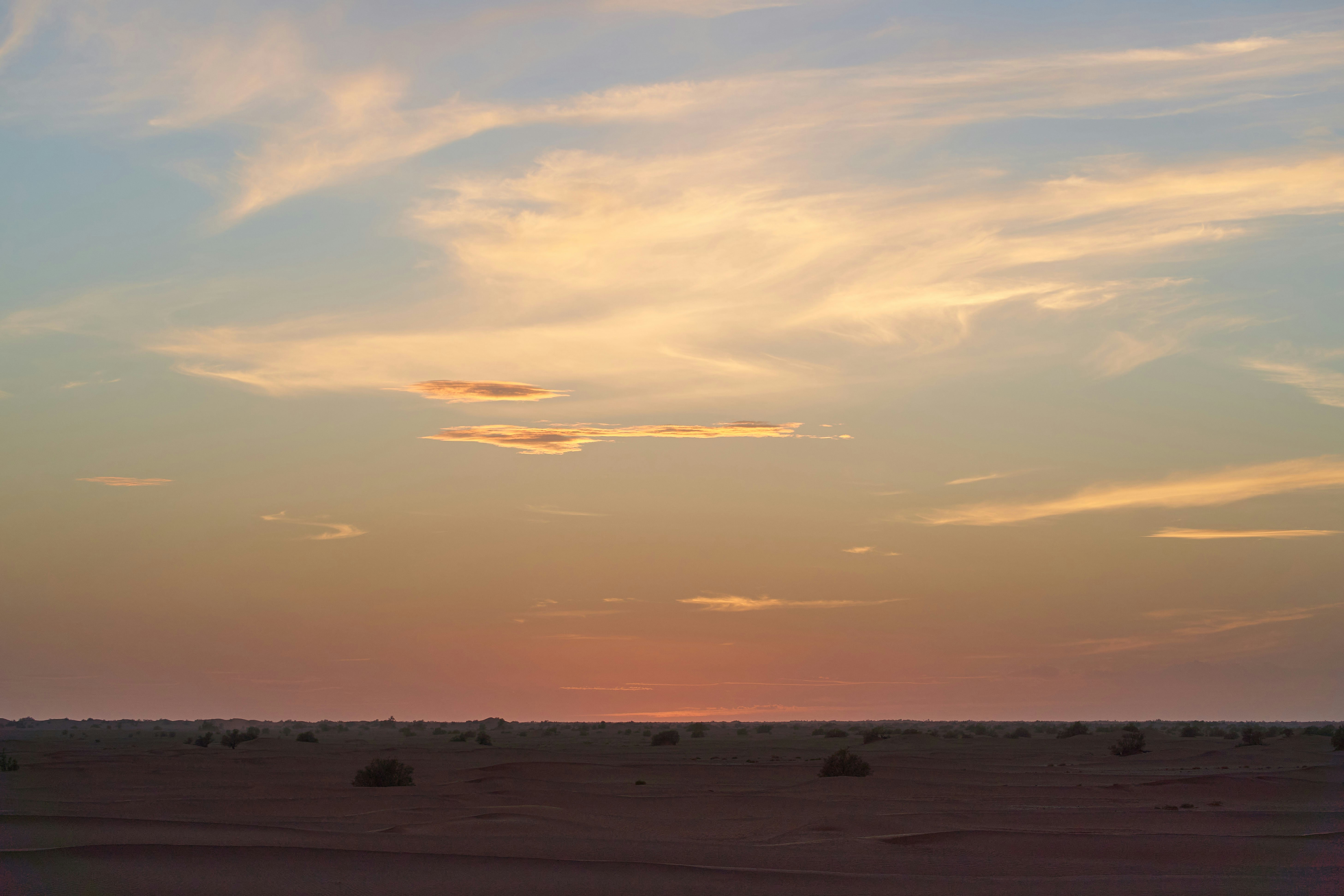 the sun is setting in the distance over the desert
