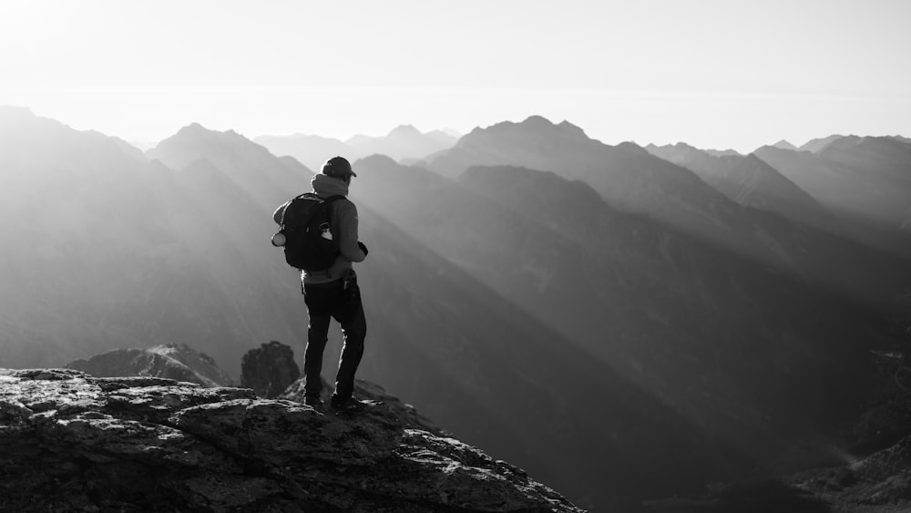 a man standing on top of a mountain with a backpack